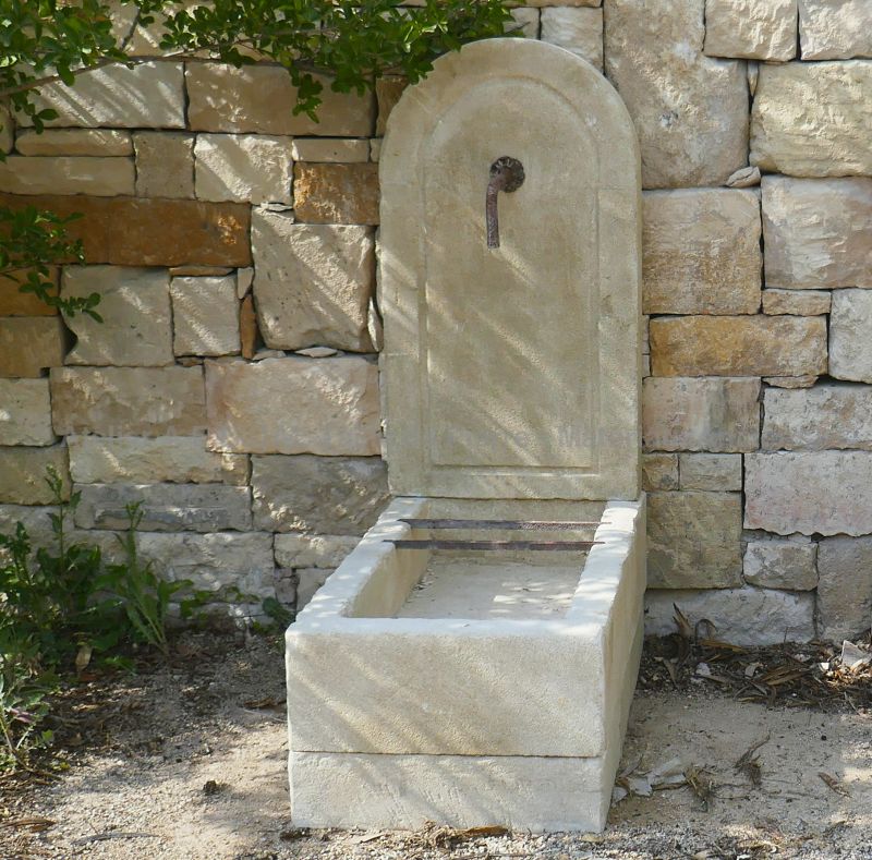 Lovely natural stone water fountain : a small wall fountain in stone by Atelier Alain Bidal.
