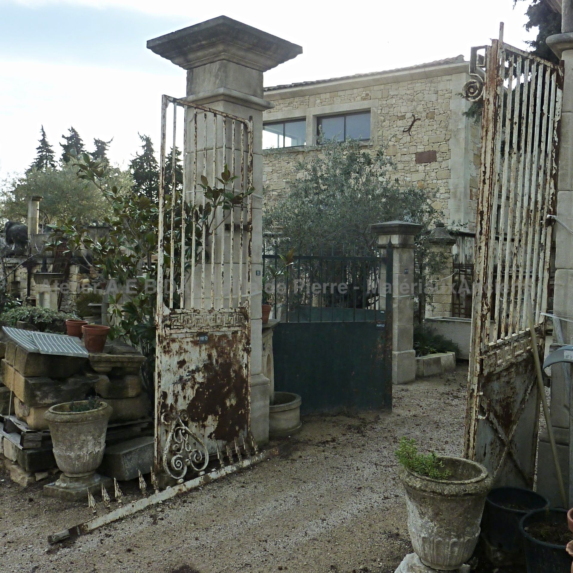 Old wrought iron gate with old double doors.