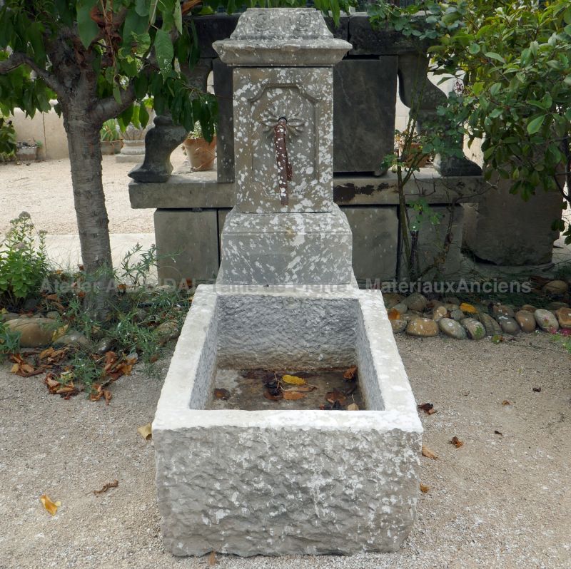 Small water fountain in reclaimed stones and wrought iron.