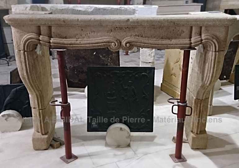 Ancient stone fireplace in a soft ocra color - beautiful decorative fireplace in a Louis 15 style.