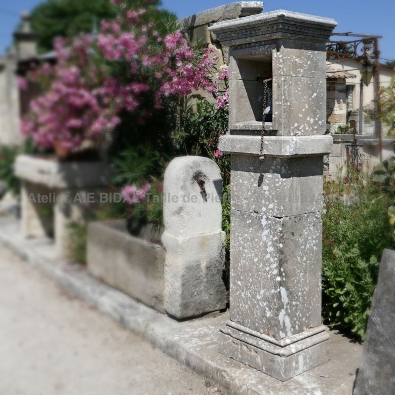 Original stone entrance pillar with antique cast iron bell on sale at Alain Bidal in Provence.