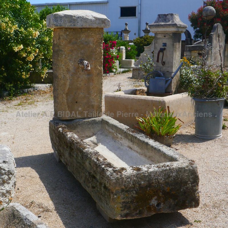 Old garden fountain : a fountain with an antique trough and high pediment in weathered stones