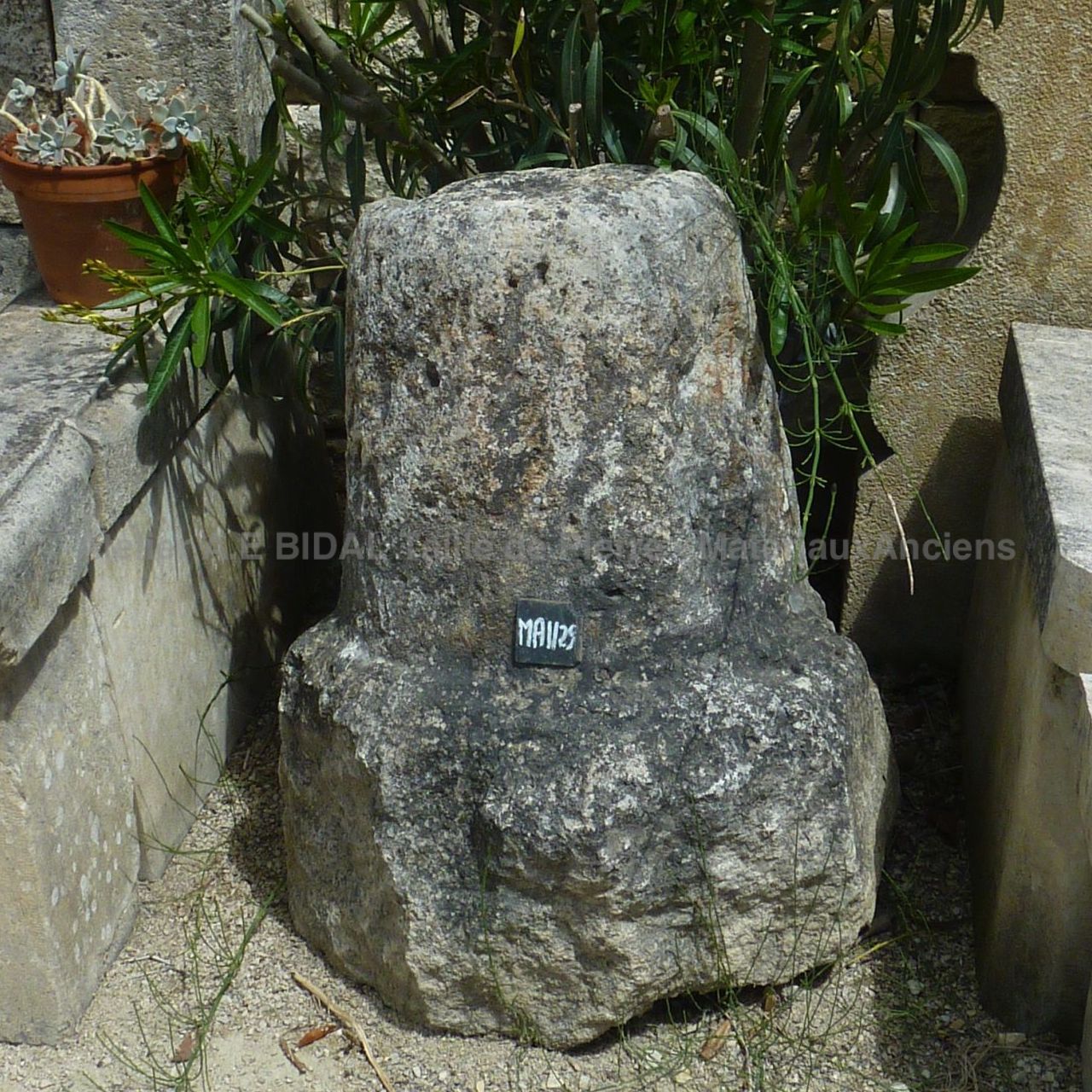 Tapered stone marker in a rustic style, made of monolithic stone.