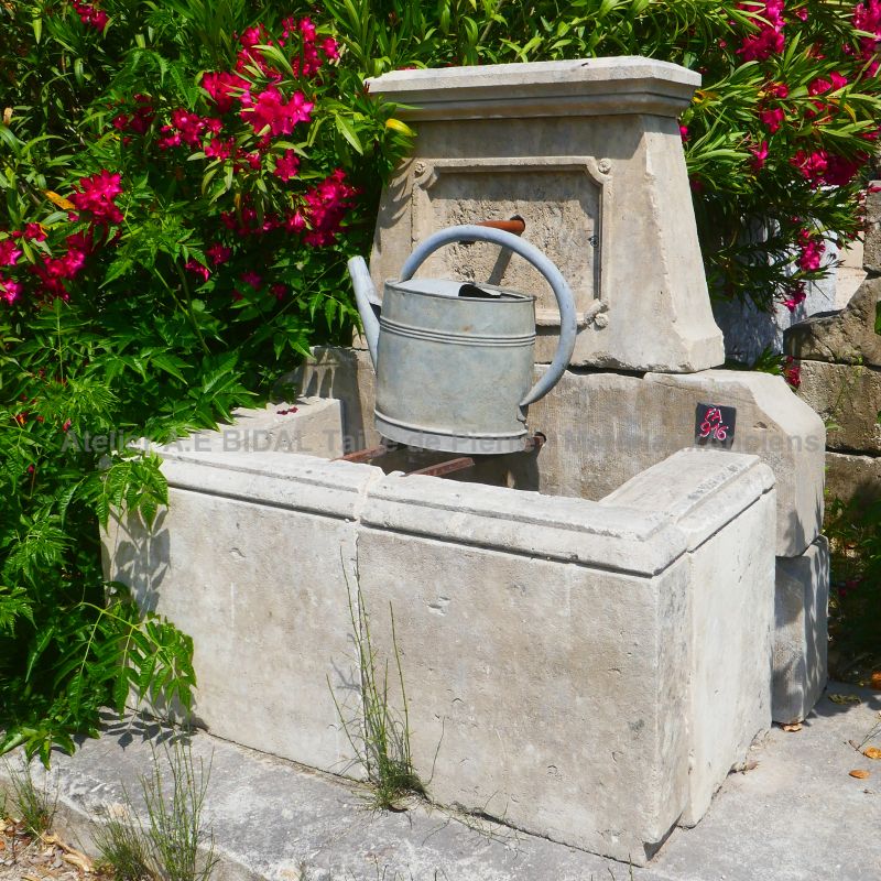 Country-style fountain in weathered stones: a small wall fountain from Atelier Alain BIDAL (Provence)