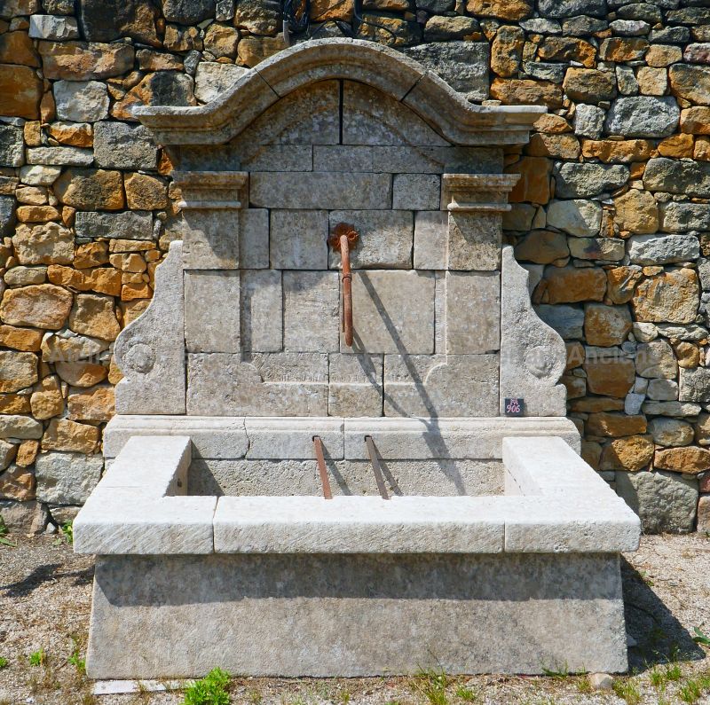 Tall and wide wall fountain : a garden fountain in weathered stones by Alain BIDAL (Provence)