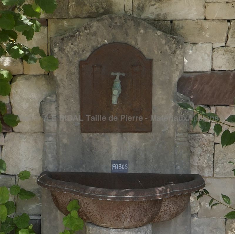 Detail of the pediment mixing stone and iron on our stone wall fountain with old cast iron standing basin.