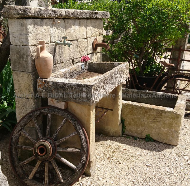 Wall stone fountain | Garden fountain with old trough and antique sink in stone.