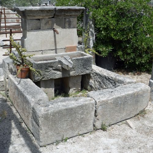 Detail of the stone pediment with water outlet, massive stone trough and spillway | Wall fountain for sale in Provence chez Alain BIDAL