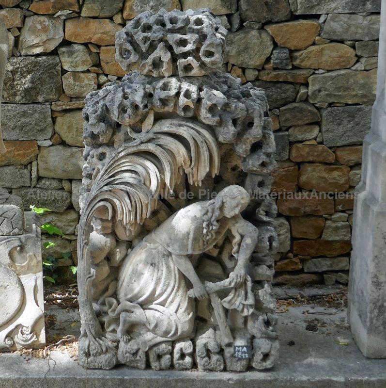 Sculpture of a woman kneeling on funerary stele with stone cross.