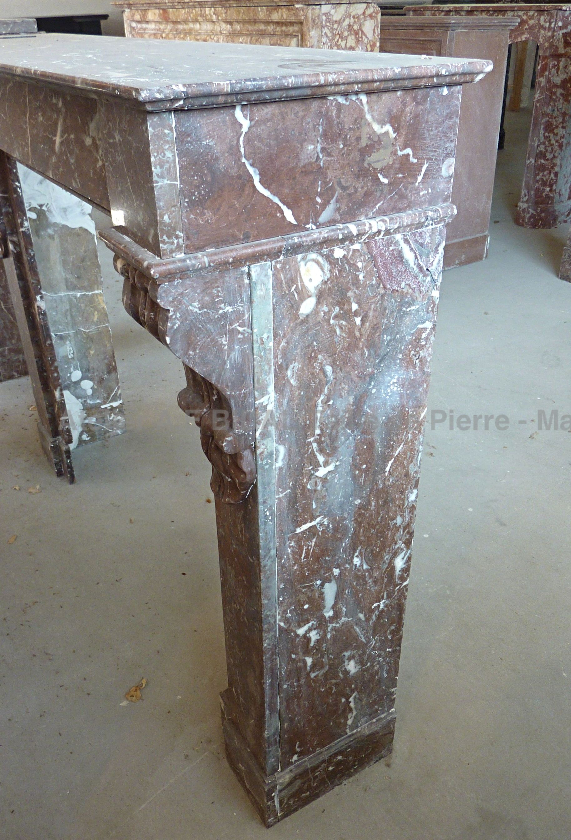 Cheminée marbre rouge décorée avec élégance d'enroulements et de beaux feuillages - cheminée ancienne Napoléon III.