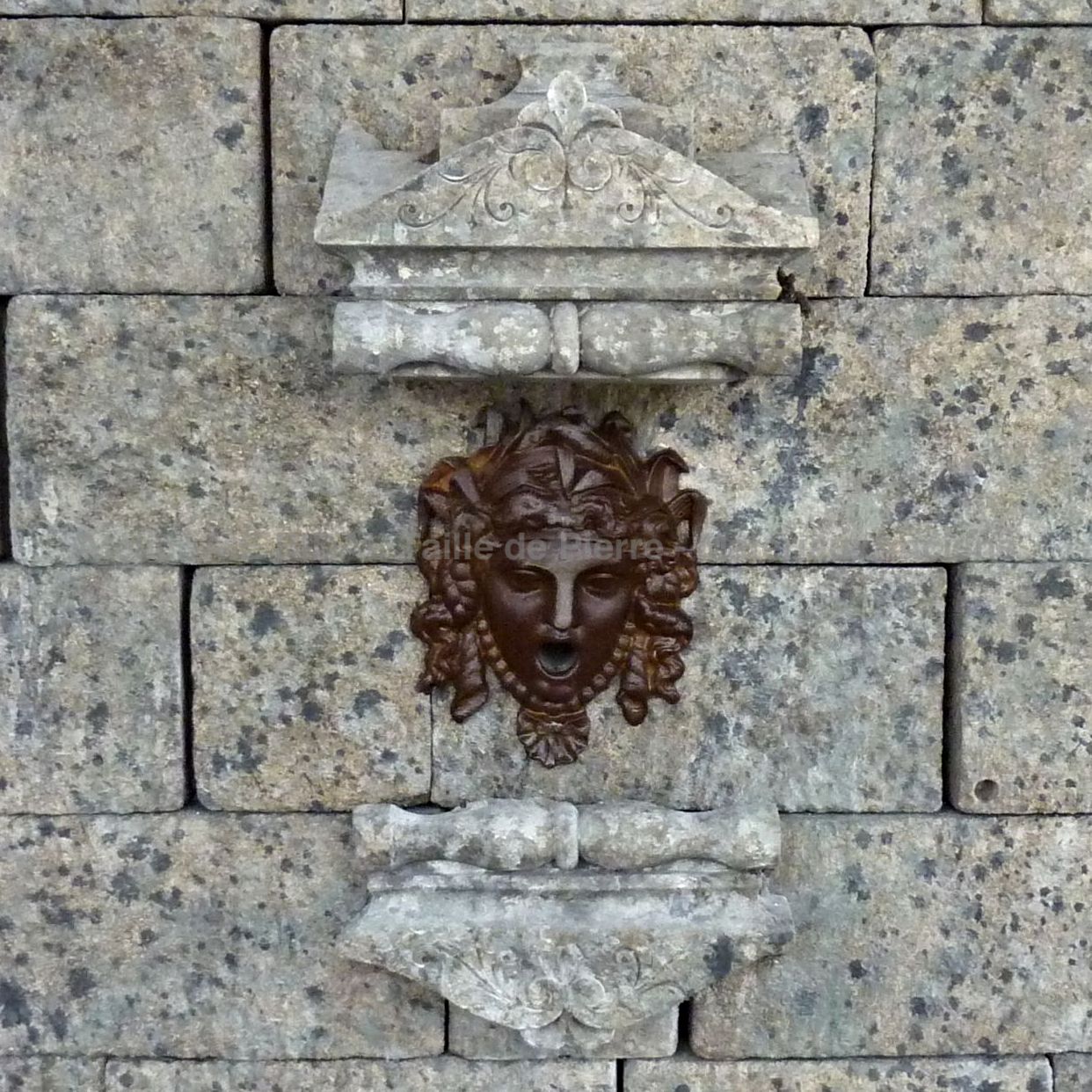 Large fountain made of natural stone and cast iron | garden wall fountain with an undeniable and unique charm.