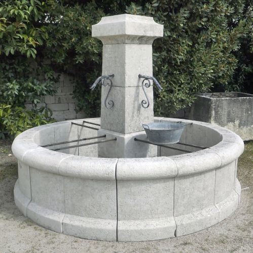 Round central fountain in weathered natural stone : Atelier Alain BIDAL (Provence)