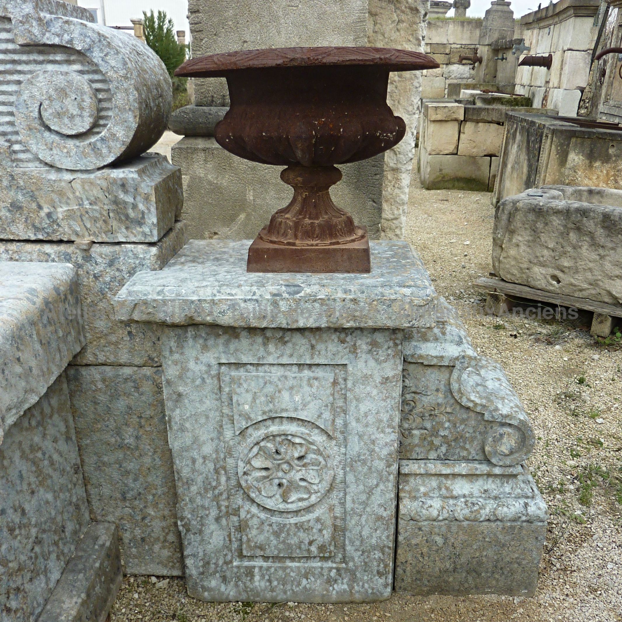 Wall fountain : a large fountain with a stone pediment, a  stone basin and antique cast iron elements.