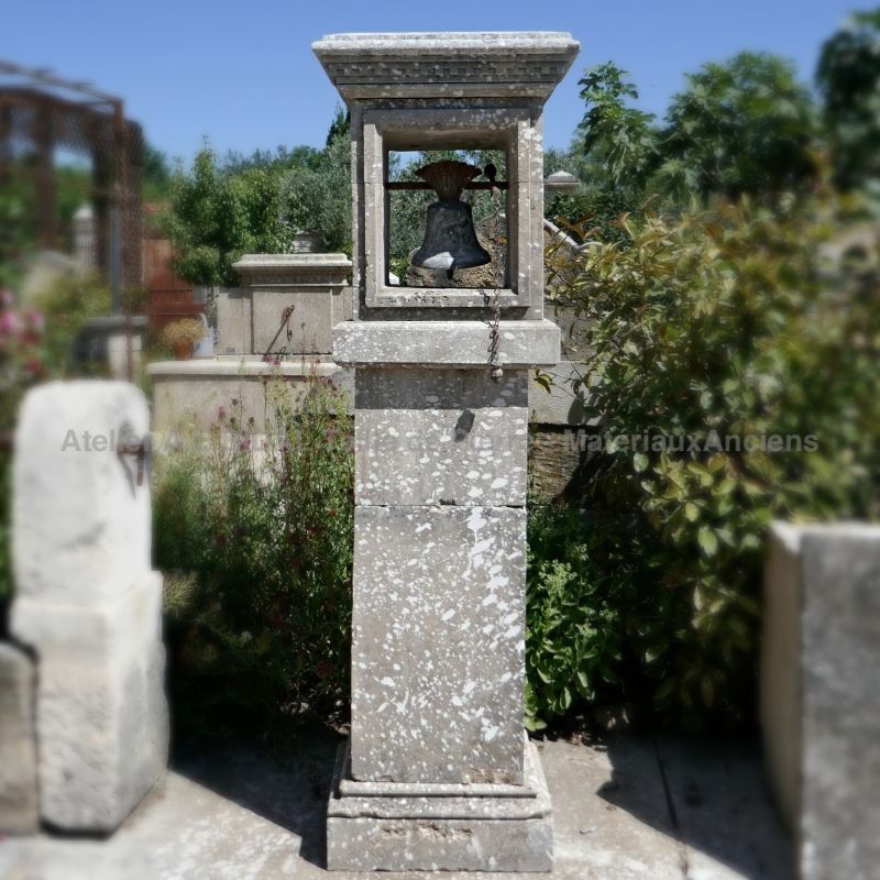 Embellish your home with this elegant stone pillar and its small antique bell.
