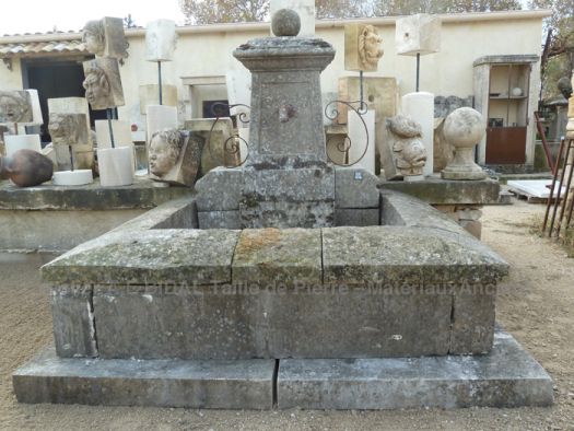 Antique stone wall-fountain with sculpted and narrow pediment