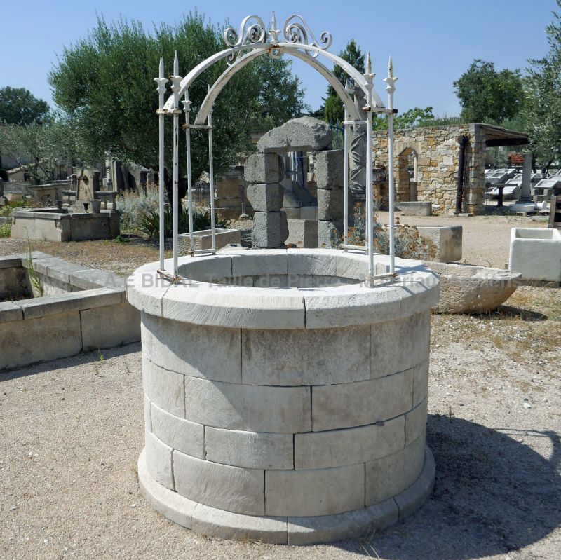 Garden well in stone with its wrought iron decorative top by Atelier Alain BIDAL.