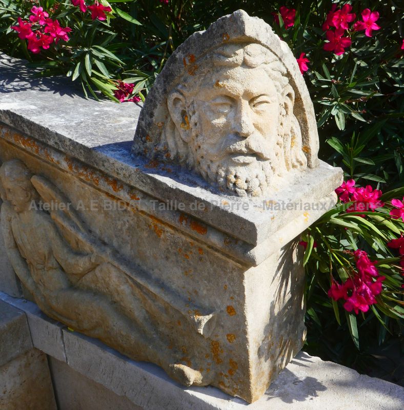 Garden fountain with pediment hand-carved with angels with trumpets and stone head : Atelier Alain BIDAL (Provence)
