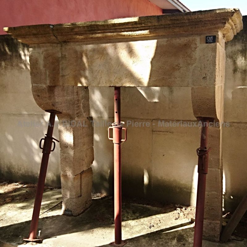 Cheminée ancienne en pierre - une cheminée avec corniche moulurée de type cheminée Louis XIII.