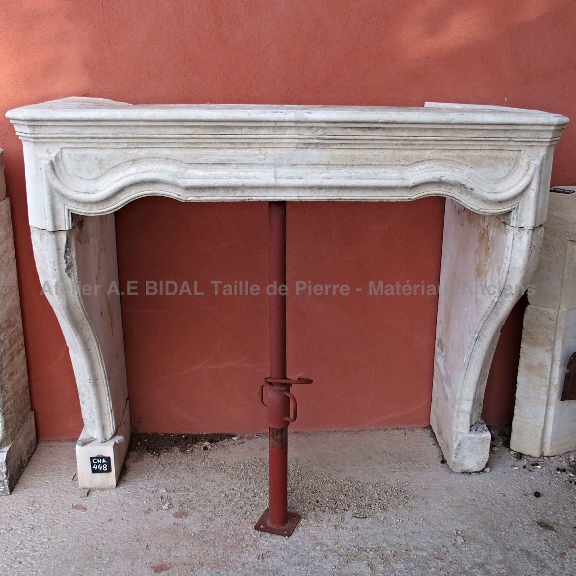 Old fireplace made of white stone - an old stone fireplace with a refined style with curves.