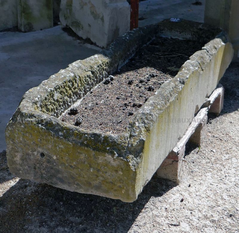 Long bac ancien en pierre ou auge rectangulaire en pierre.