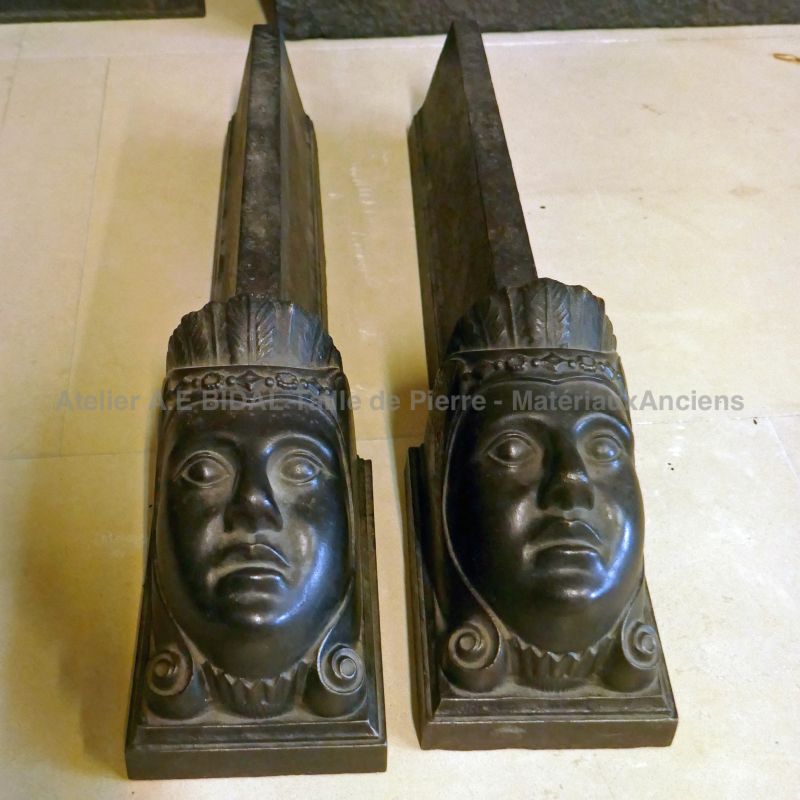 Anciens chenets en fonte noire ornés de visages féminins - la paire