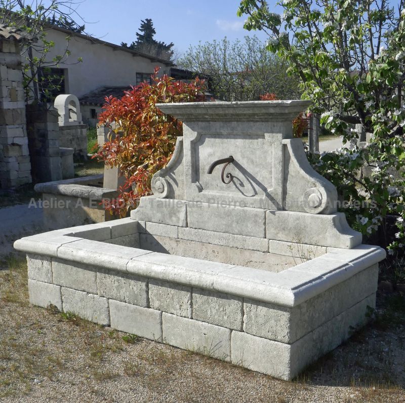 Large rustic-looking fountain in weathered stones by the stonemason in Provence Alain BIDAL