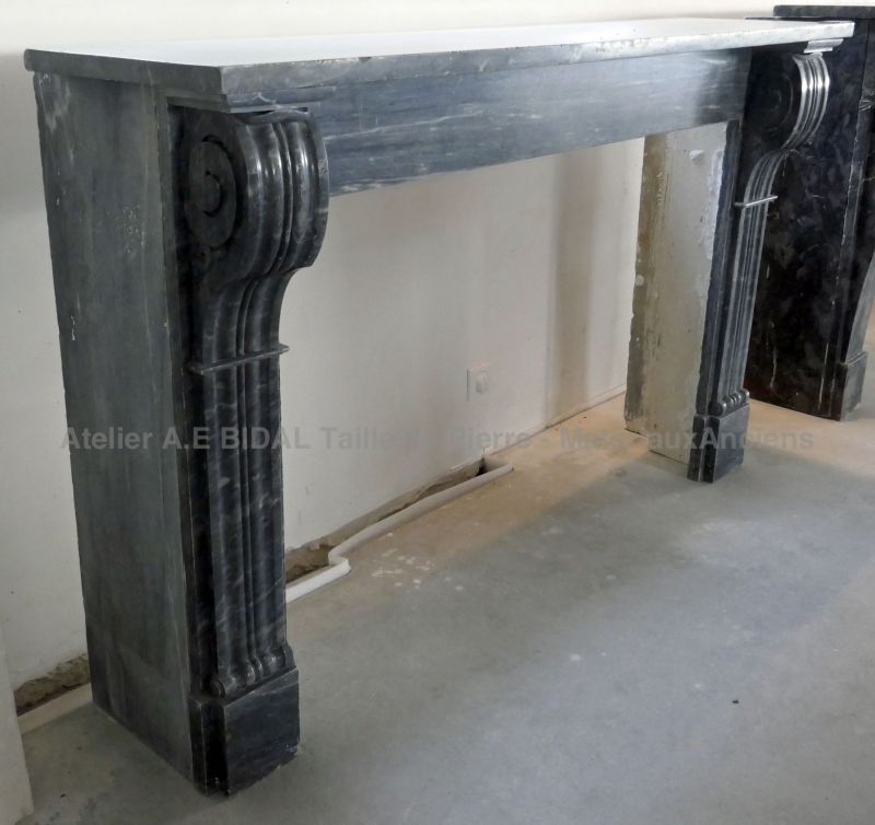 Cheminée en marbre noir d'époque Restauration - cheminée ancienne en marbre noir veiné de blanc.