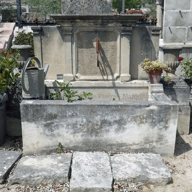 Wall fountain with decorative pediment | Antique garden fountain made of wrought iron and ancient stone.