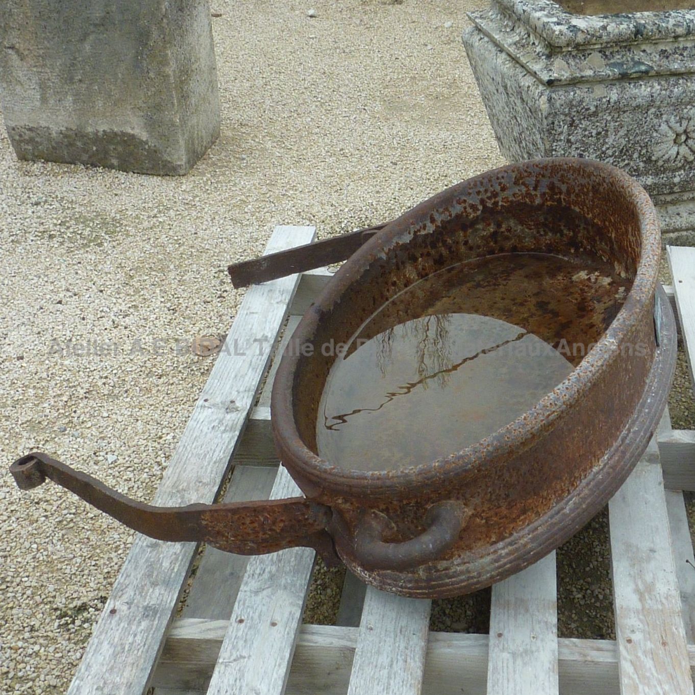 Old trough decorated with moldings and a forged flower - old trough for an authentic decoration.