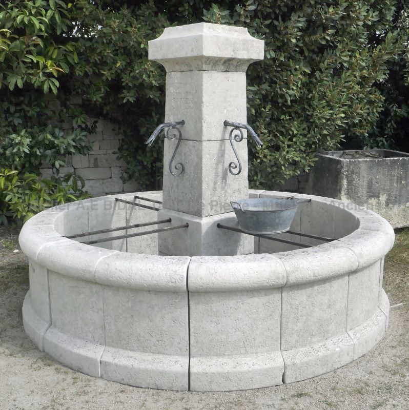 Round central fountain in weathered natural stone : Atelier Alain BIDAL (Provence)