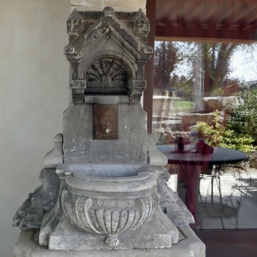 Pretty wall fountain with hand sculpted holy water stoup in stone | Small garden fountain with antique religious elements.