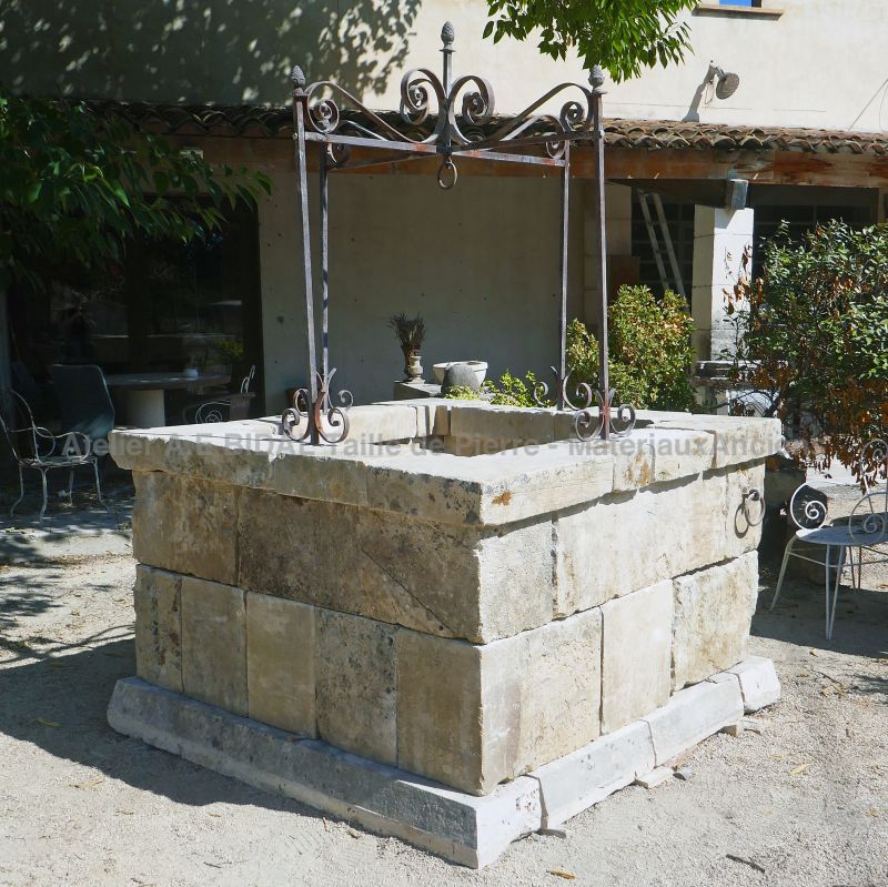 Garden well in stone and its scrap metal top structure for sale in Provence at Alain BIDAL Matériaux Anciens.