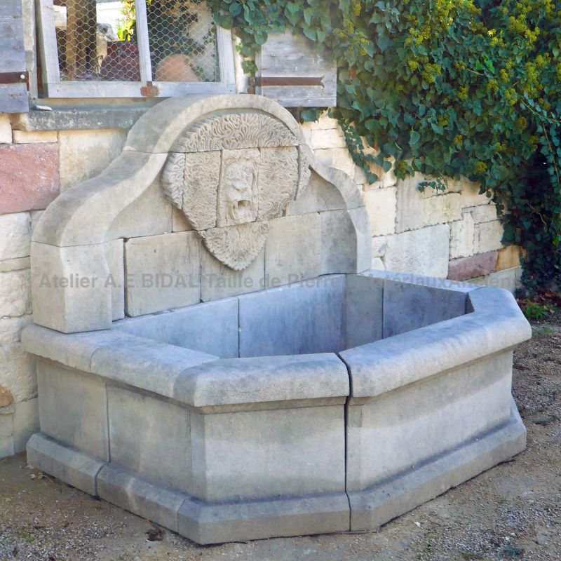 Garden fountain with hand-sculpted pediment with a large stone lion's head : Atelier Alain BIDAL, Provence