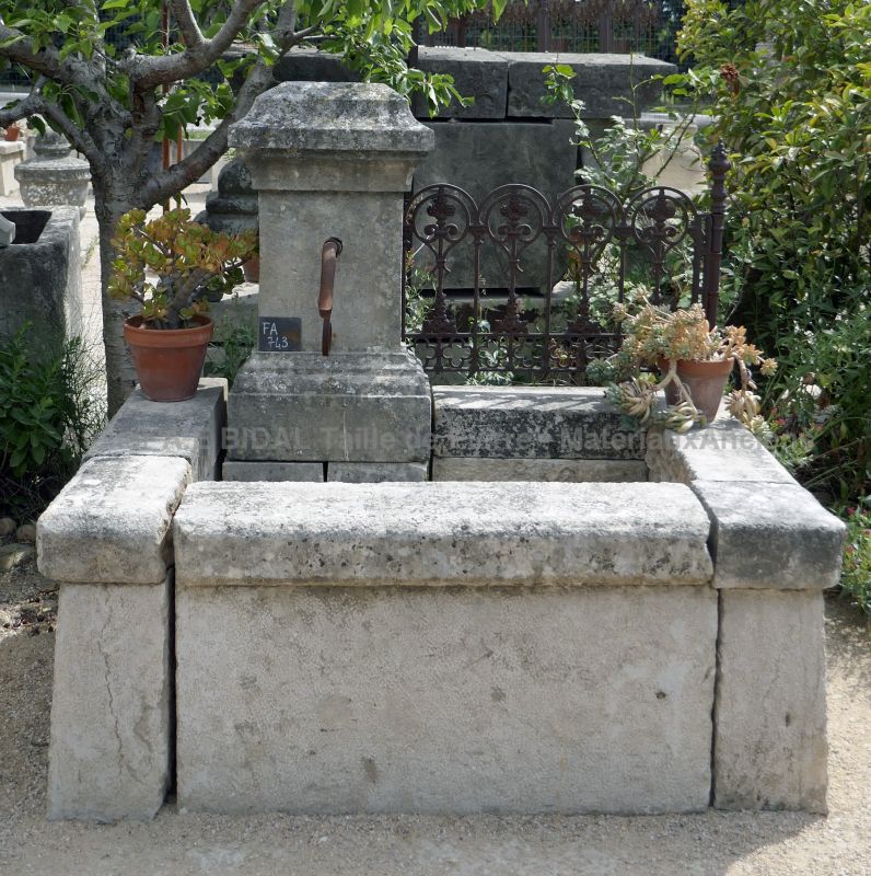 Petite fontaine de jardin en pierre : une fontaine ancienne murale.