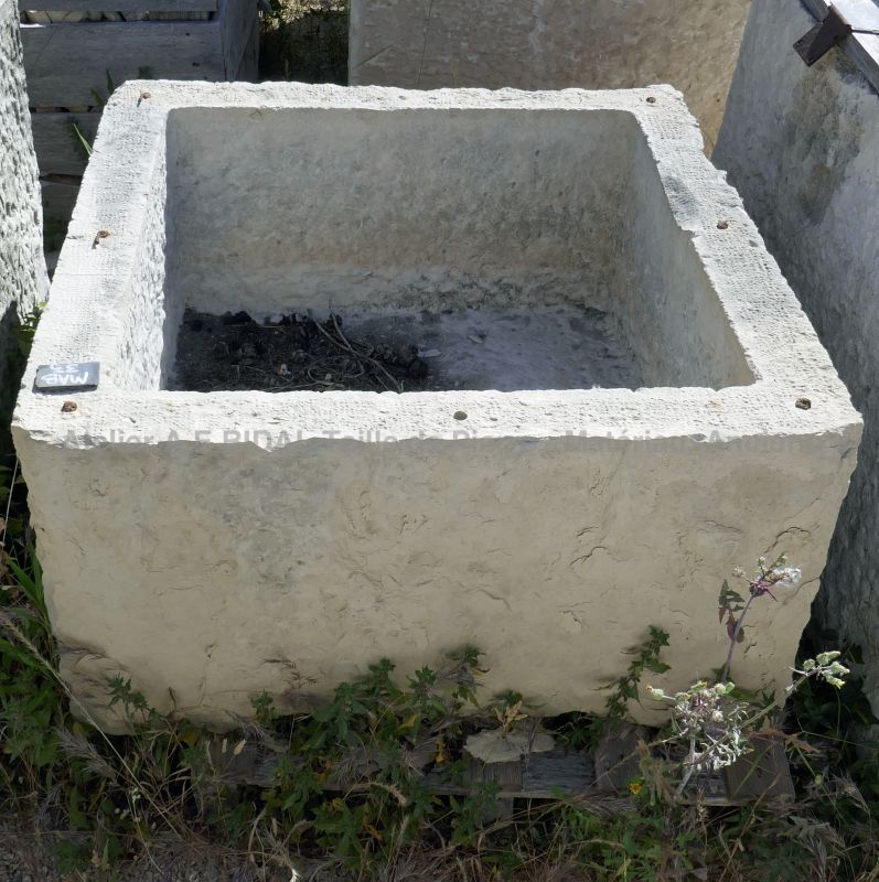Bac rectangulaire avec traces de ferraille apparentes sur le dessus - bac ancien en pierre.