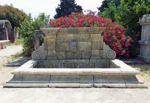 Large wall fountain in reclaimed old stones with sculpted mascaron and molded basin - Atelier Alain BIDAL (Provence)