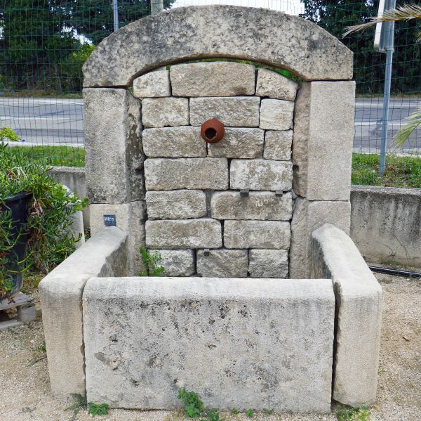 Fontaine murale, une fontaine de jardin faite en pierres appareillées seulement.