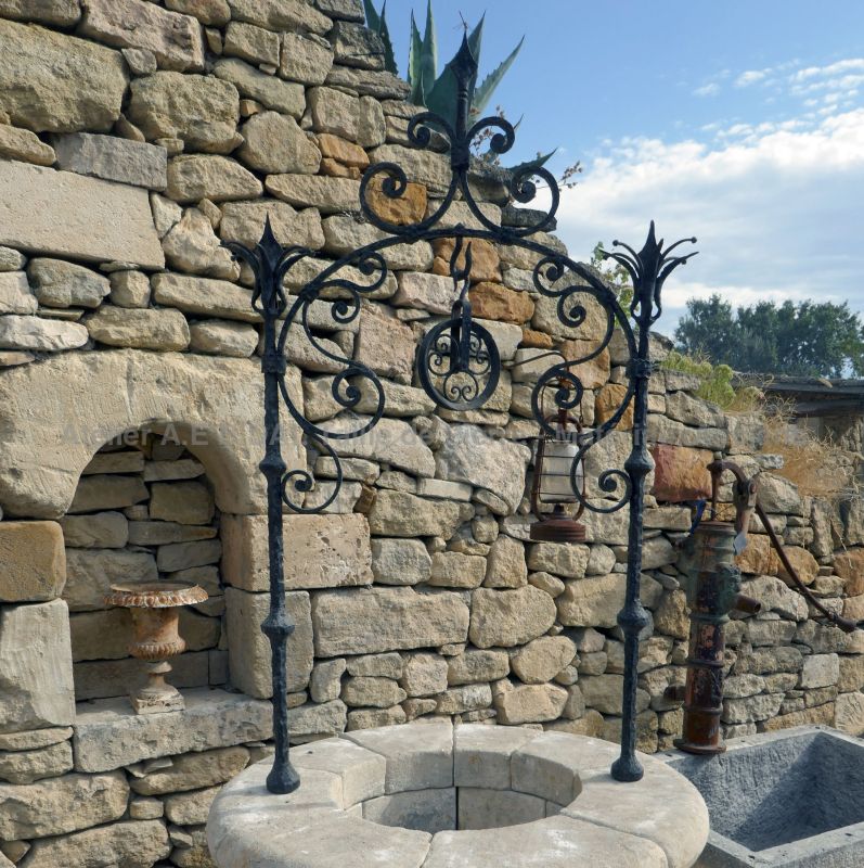 Detail of the iron well-top on our round garden well in stone | Stone well on sale at Alain BIDAL in Provence.