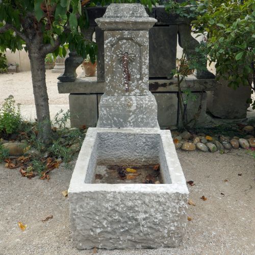 Small water fountain in reclaimed stones and wrought iron.