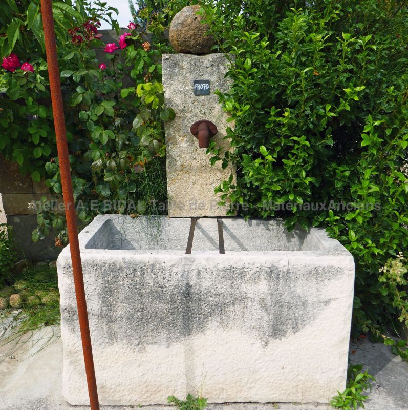 Fontaine de jardin ancienne en pierre avec bac ancien en vente chez Alain Bidal, tailleur de pierre en Provence.