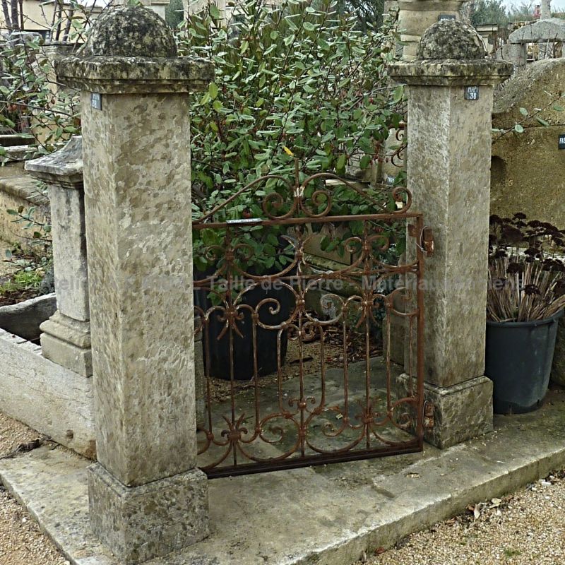 Pilier ancien mis en situation: pilier ancien qui soutient un portail en fer forgé.