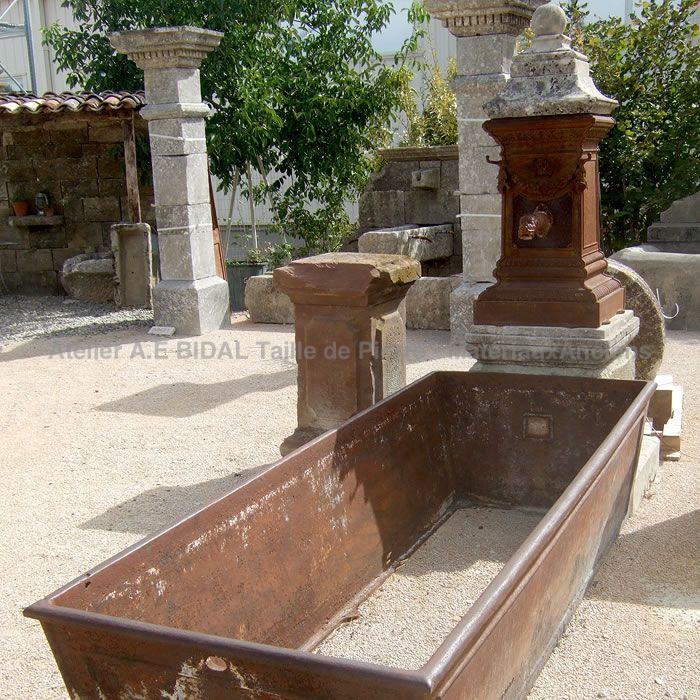 Fontaine ancienne avec fronton et bac en fonte