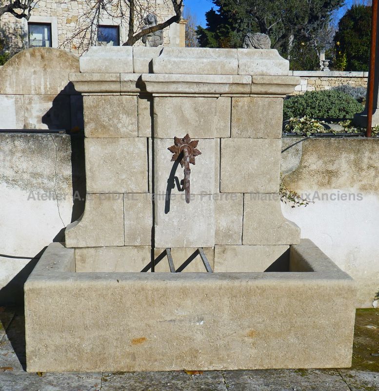 Garden fountain with low basin and pediment worked in stone: Atelier Alain BIDAL, Provence