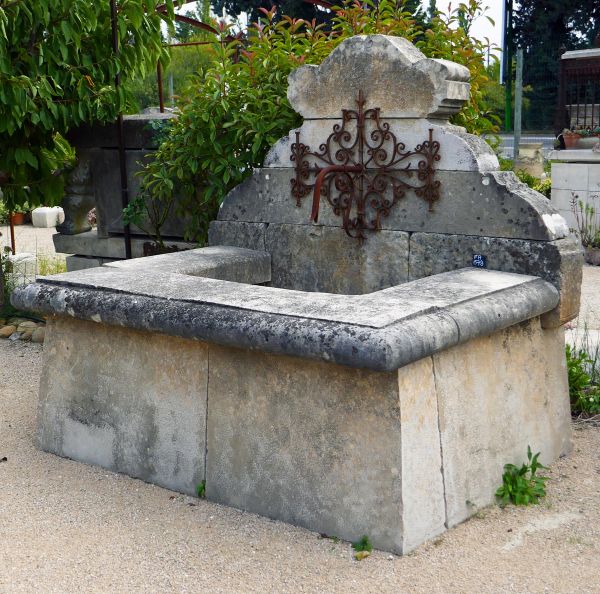 Large fountain with basin: an handmade wall fountain made of old stone and wrought iron.