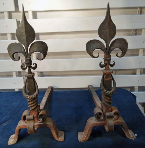 Anciens landiers en fonte noire joliment torsadés et ornés de fleurs de lys- la paire