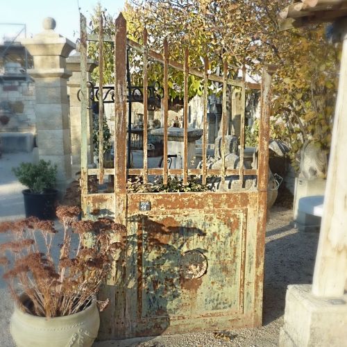 Antique wrought iron gate of rural charm with fixed frame.