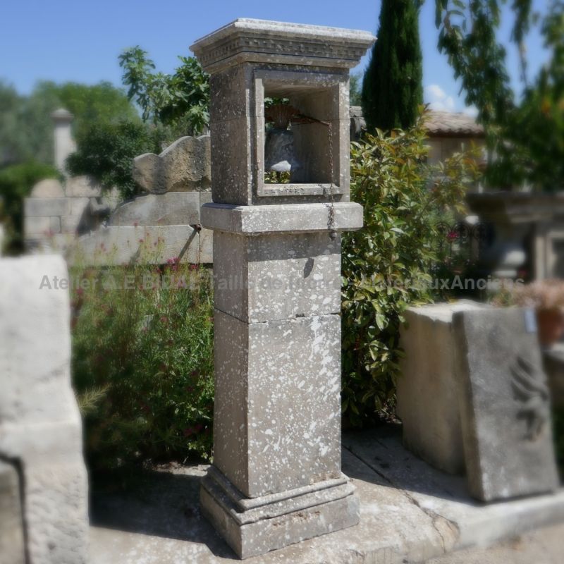Ee pillar in natural stone with niche and antique bell - Alain Bidal in Provence.