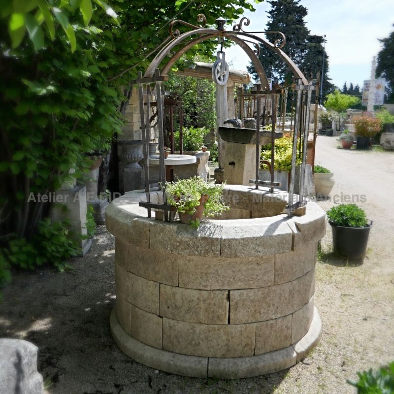Puits rond en pierre et son haut de puits en fer forgé avec poulie ** VENDU