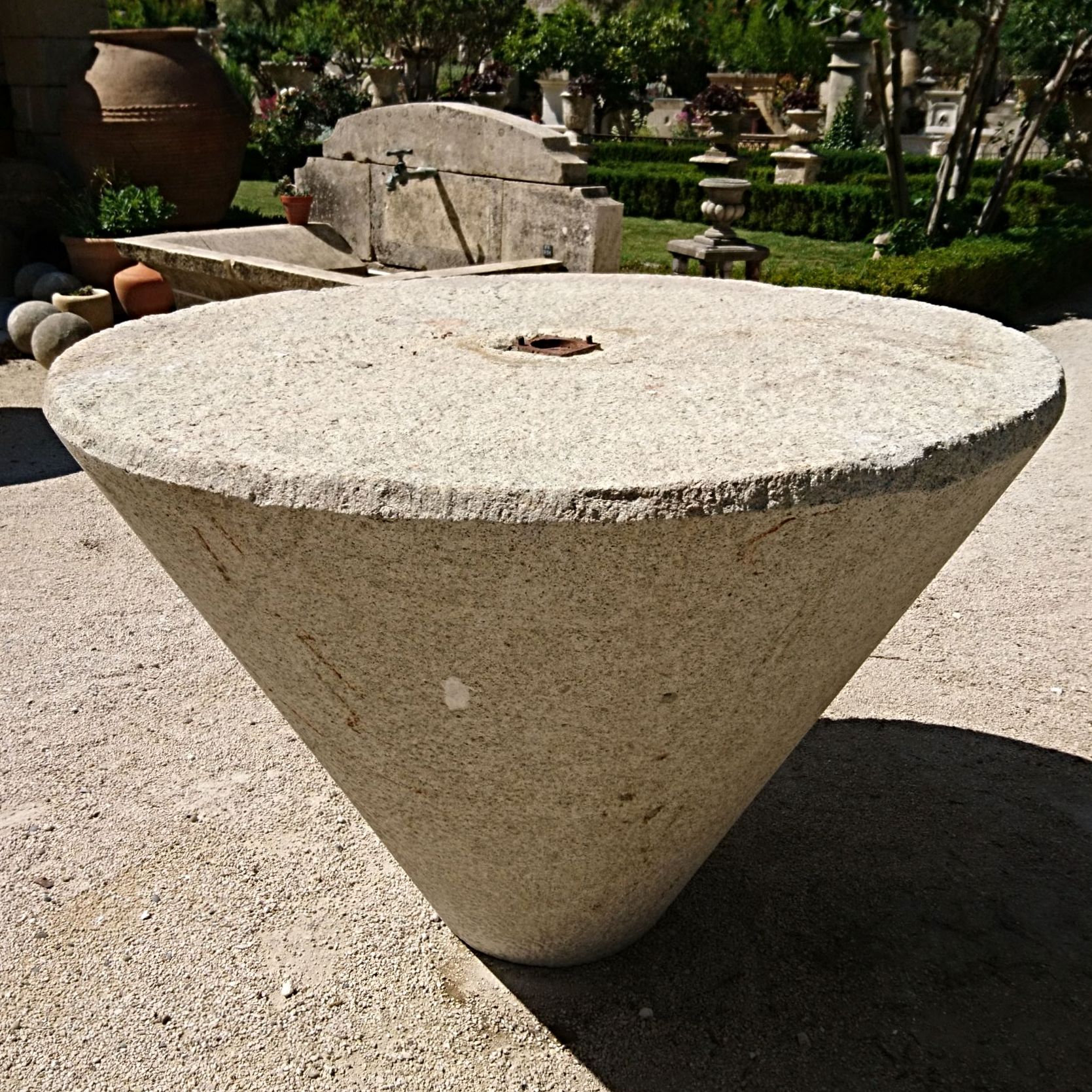 Idéale pour les petits espaces, cette haute table en pierre de style mange debout est de forme conique.