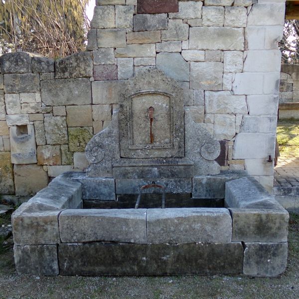 Antique fountain in patinated stone : a stone wall fountain from the Atelier Alain BIDAL (Provence)